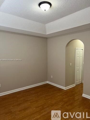 A room with a wooden floor and a white door.