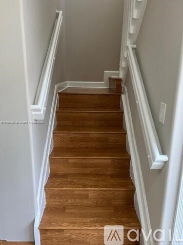 A wooden staircase with white railings.