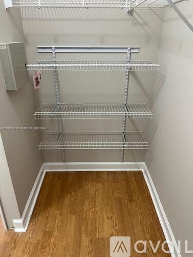 Empty shelves in a room with wooden flooring.