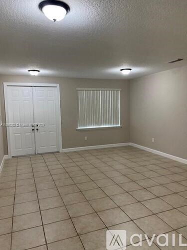 A room with a white door and a window with blinds.