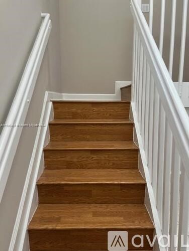 A wooden staircase with white railings.