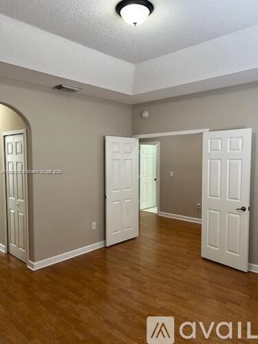 A room with wooden floors and white doors.