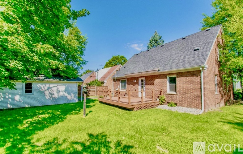 A house with a white garage and a brick house with a porch.