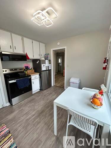 A kitchen with yellow walls and white cabinets.