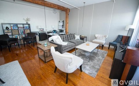 A living room with a white chair and a grey couch.