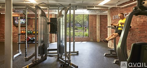 A man is working out on a leg press machine in a gym.