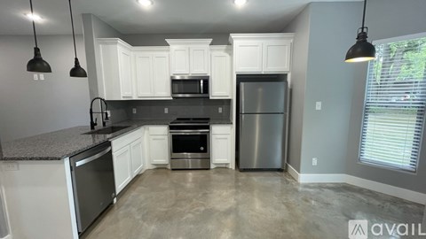 A kitchen with white cabinets and stainless steel appliances.