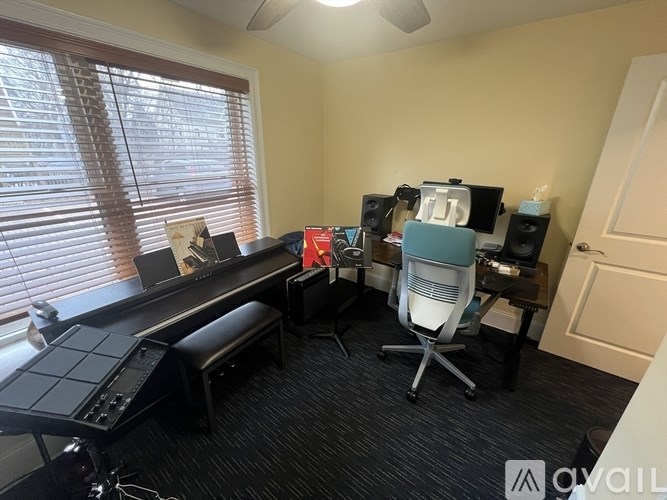 A room with a desk, chairs, and a computer setup.