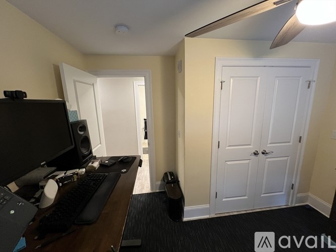 A room with a desk, computer, and keyboard.