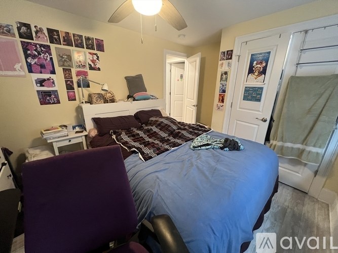 A bedroom with a bed, chair, and pictures on the wall.
