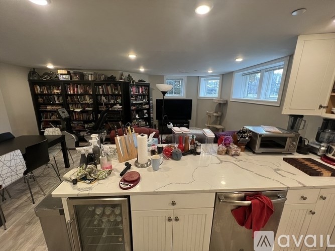 A kitchen with a large island and a bookshelf filled with books.