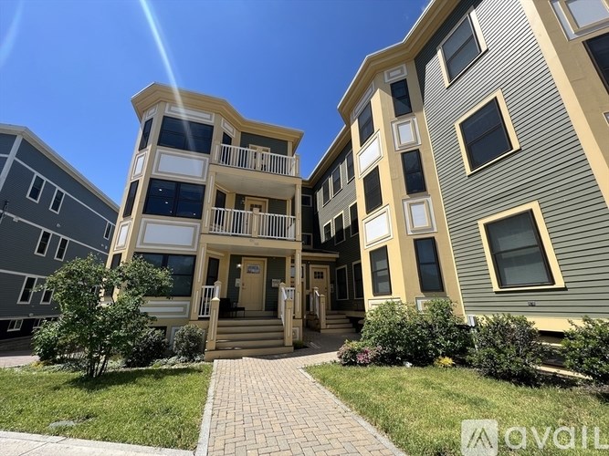 A sunny day at a modern apartment complex with a clear blue sky.