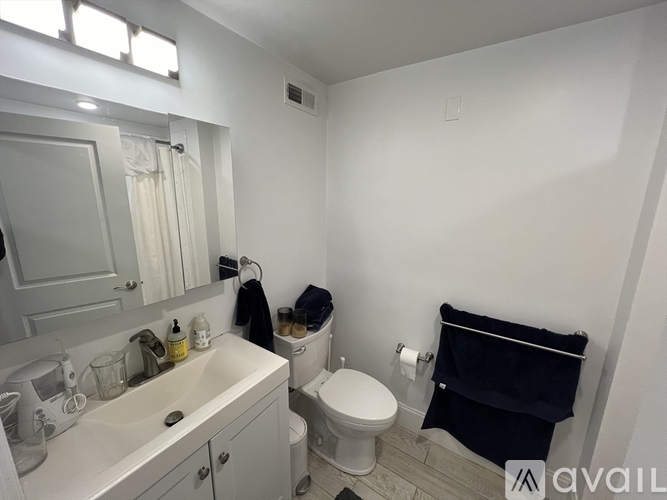 A bathroom with a toilet, sink, and mirror.