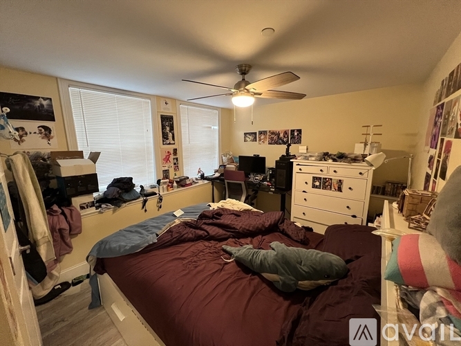 A bedroom with a bed, dresser, and a ceiling fan.