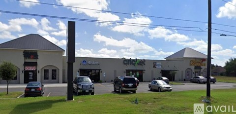 A parking lot with cars and a building with a sign that says "Alberts".