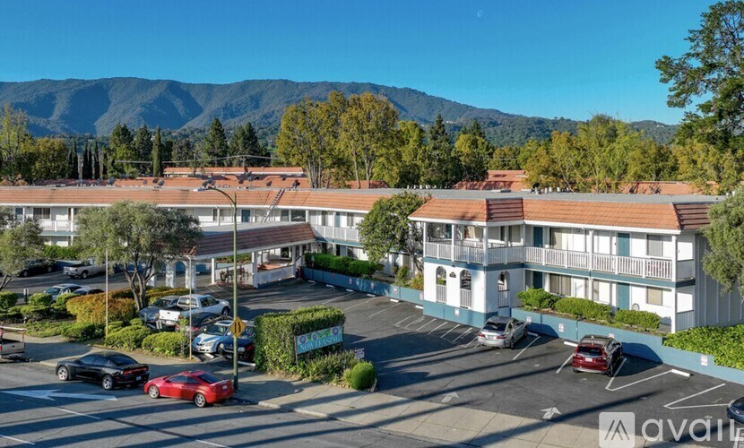 A parking lot with cars and a mountain in the background.