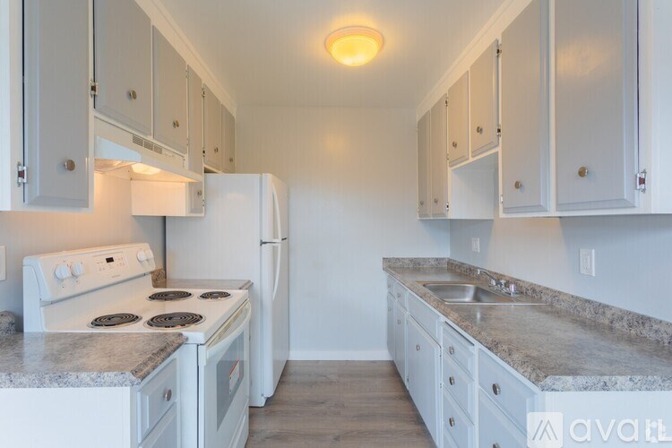 A kitchen with white appliances and cabinets.