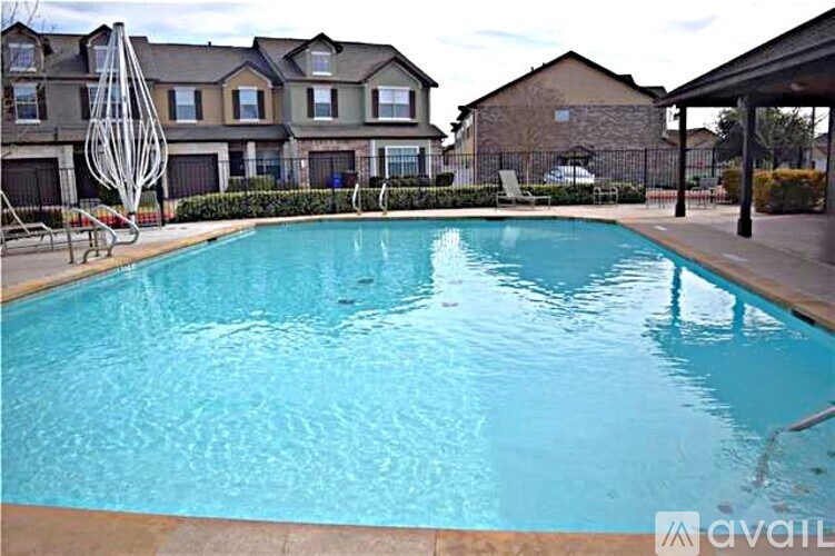 A swimming pool in a residential area with houses in the background.