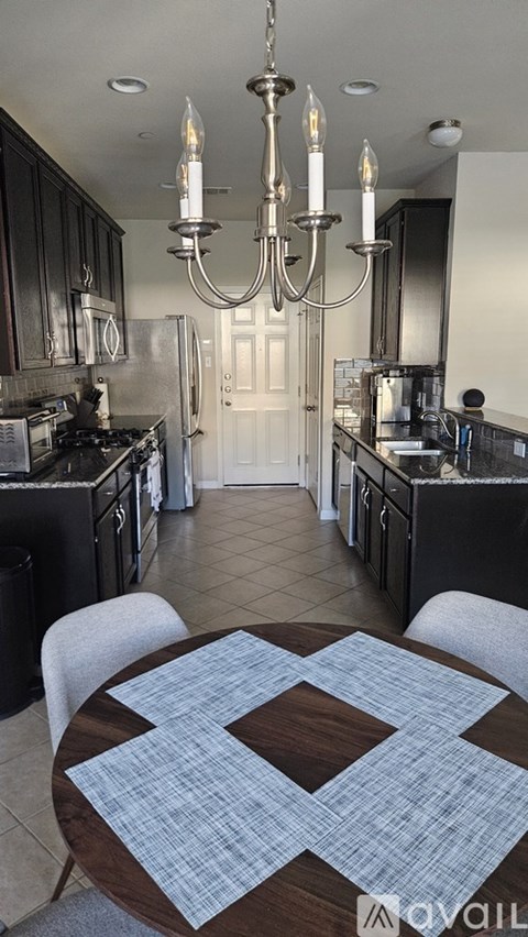 A kitchen with black cabinets and a granite countertop.