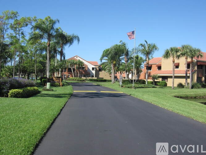 A street view of a residential area with houses and palm trees.