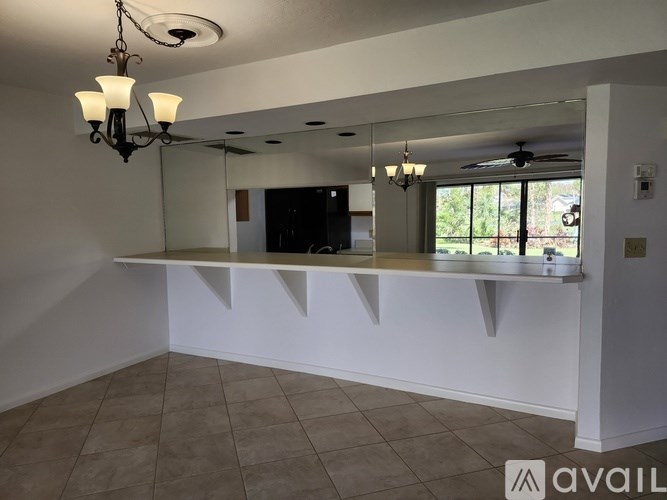 A room with a large mirror, a chandelier, and a fan.