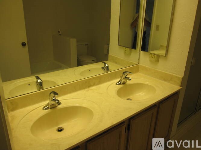 A bathroom with two sinks and a large mirror.