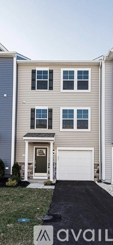 A two-story house with a garage and a driveway.