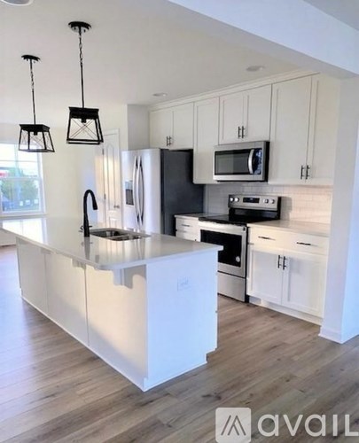 A kitchen with white cabinets and a black stove top oven.