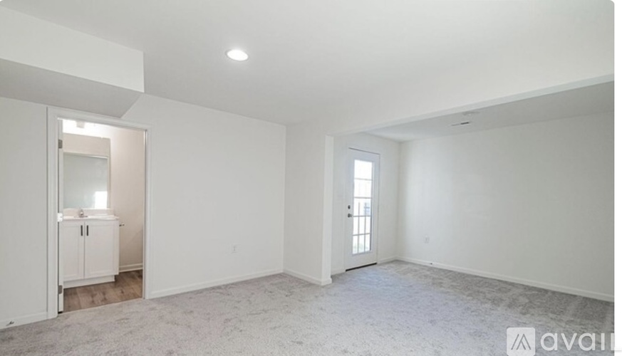 A spacious, empty room with a cabinet and a door visible.