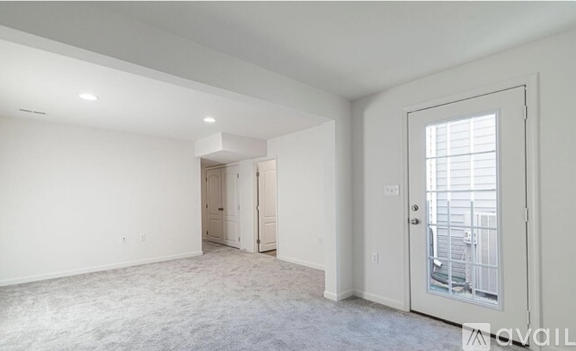 A spacious room with a door leading to a balcony.