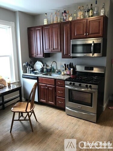 A kitchen with wooden cabinets and a stainless steel oven.