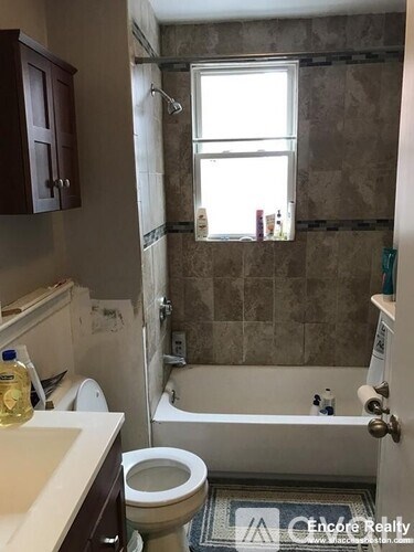 A bathroom with a toilet, sink, and bathtub.