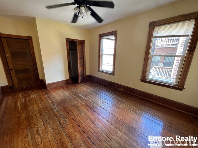 A room with wooden floors and a ceiling fan.