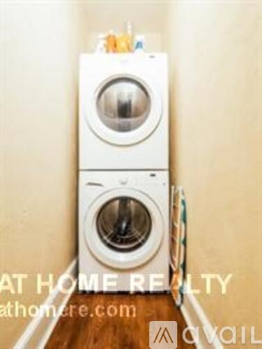 A white washing machine is stacked on top of another in a small space.