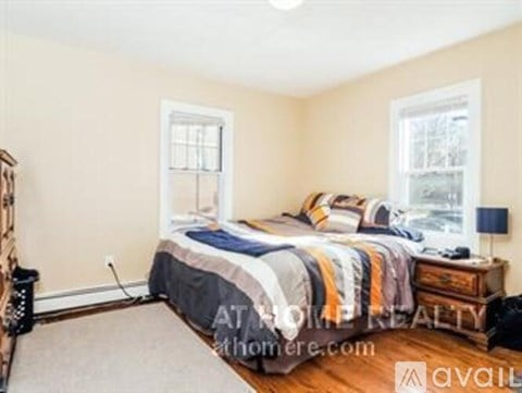 A bedroom with a bed, nightstand, and lamp.