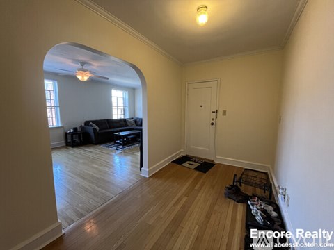 A spacious room with a wooden floor and a white door.