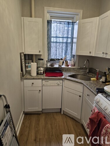 A kitchen with white cabinets and appliances.