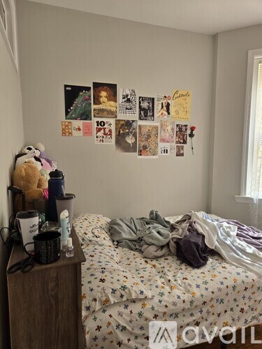 A bedroom with a bed, a nightstand with a teddy bear, and pictures on the wall.