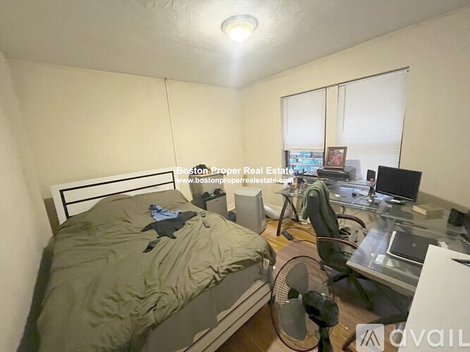 A bedroom with a bed, desk, and chair.