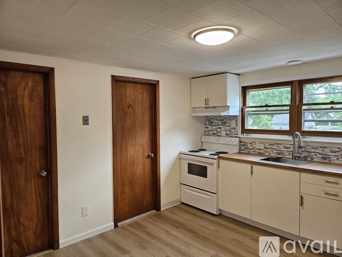 A kitchen with wooden doors and white cabinets.