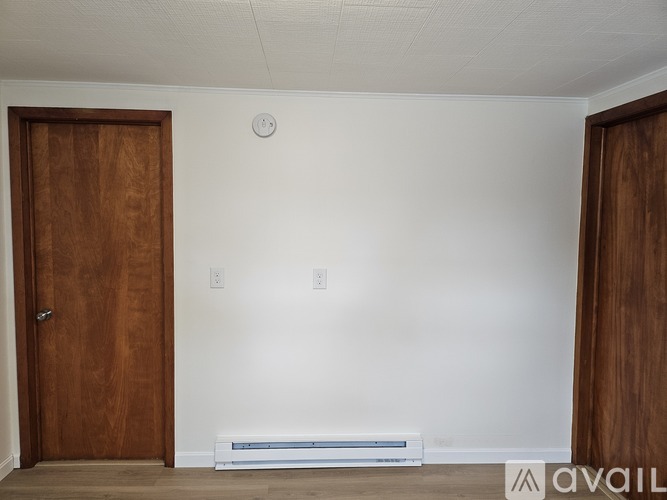 A room with two doors and a wall-mounted air conditioner unit.