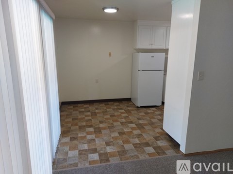 A kitchen with white cabinets and a white refrigerator.