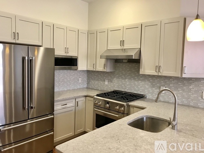 A kitchen with a stainless steel refrigerator and a sink.