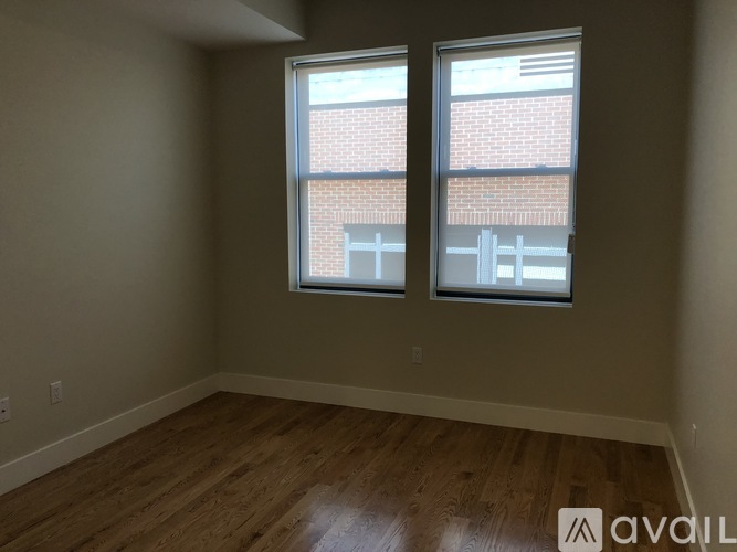 A room with wooden floors and two windows.