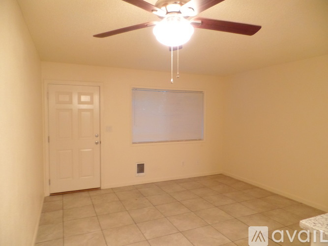 A room with a ceiling fan and a door.