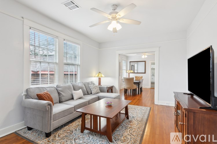 A living room with a grey couch, a wooden coffee table, and a flat screen TV.