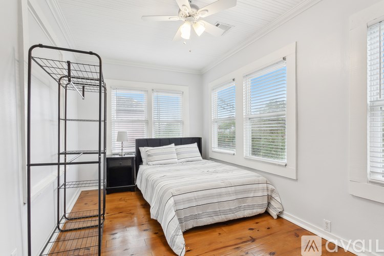 A bedroom with a four poster bed and a wooden floor.