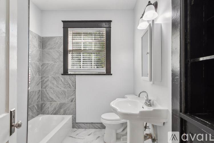 A bathroom with a white sink, toilet, and bathtub.