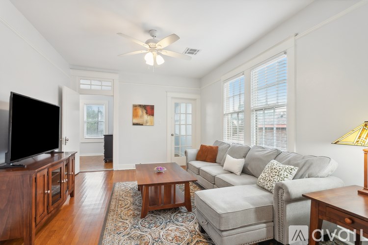A living room with a grey couch, a wooden coffee table, and a flat screen TV.