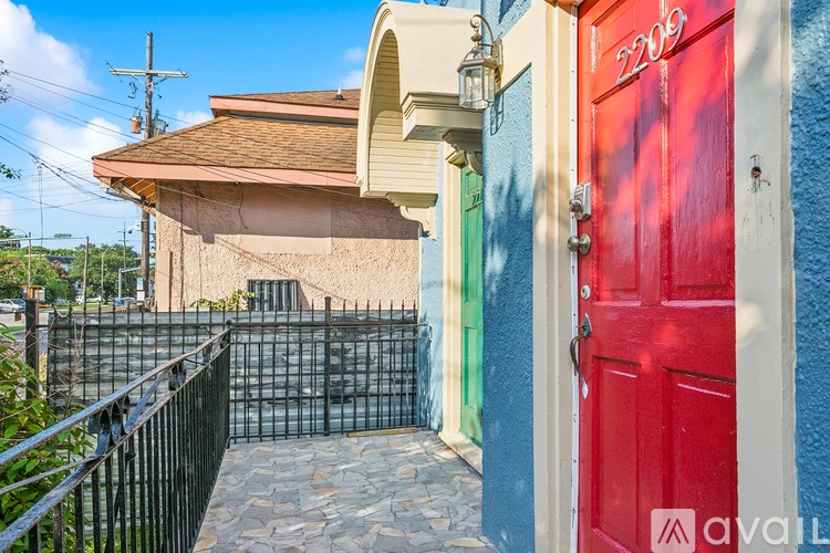 A red door with the number 2209 on it is in front of a blue wall.
